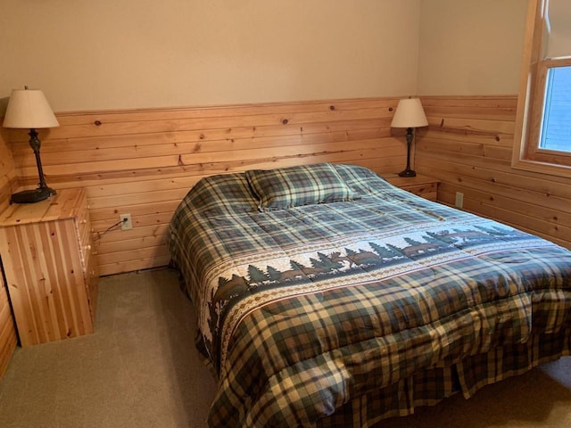 bedroom with carpet floors and wooden walls