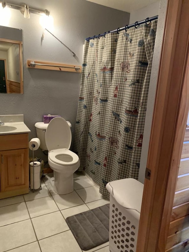 bathroom with vanity, curtained shower, toilet, and tile patterned floors