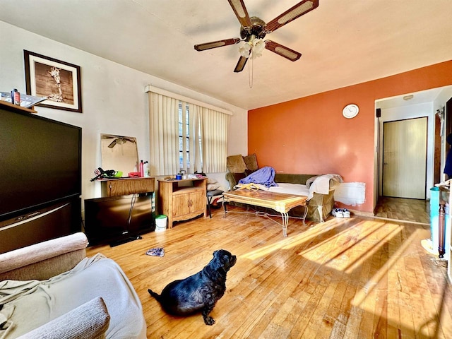 living area with wood-type flooring and a ceiling fan