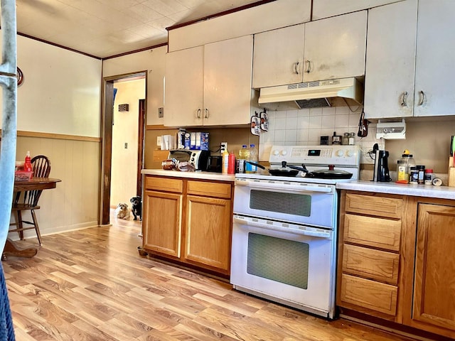 kitchen with light hardwood / wood-style flooring, crown molding, and electric stove