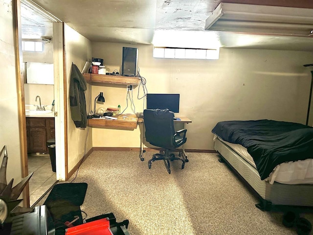 bedroom featuring a sink, baseboards, and ensuite bathroom