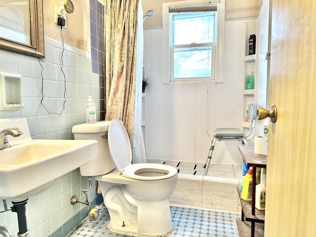 bathroom with toilet, a shower with curtain, tile walls, and tile patterned flooring