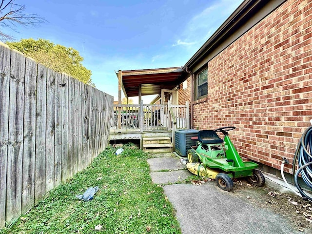 view of yard featuring a wooden deck and central AC unit