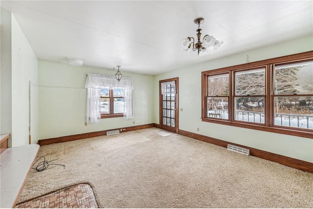 interior space featuring light carpet, an inviting chandelier, and a wealth of natural light