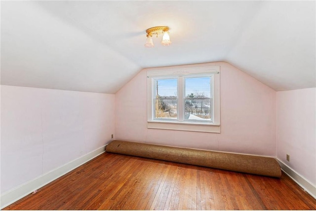 additional living space featuring wood-type flooring and vaulted ceiling