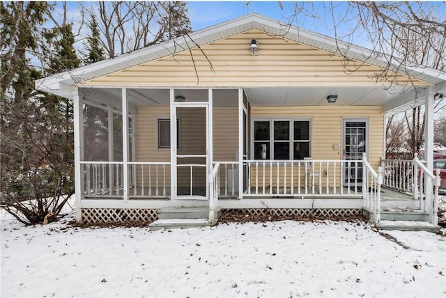 view of front of home featuring covered porch and a sunroom