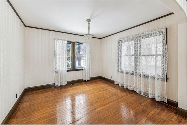 unfurnished room featuring ornamental molding and hardwood / wood-style floors