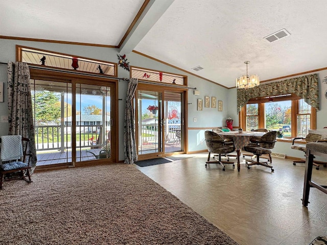 dining room featuring vaulted ceiling with beams, a textured ceiling, and a wealth of natural light