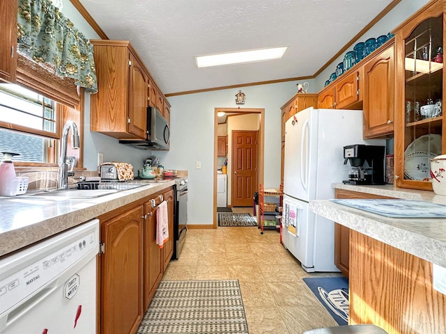 kitchen with sink, stainless steel appliances, ornamental molding, and lofted ceiling