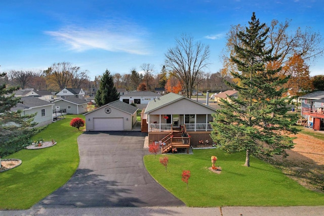 view of front of house featuring covered porch, a front yard, and a garage