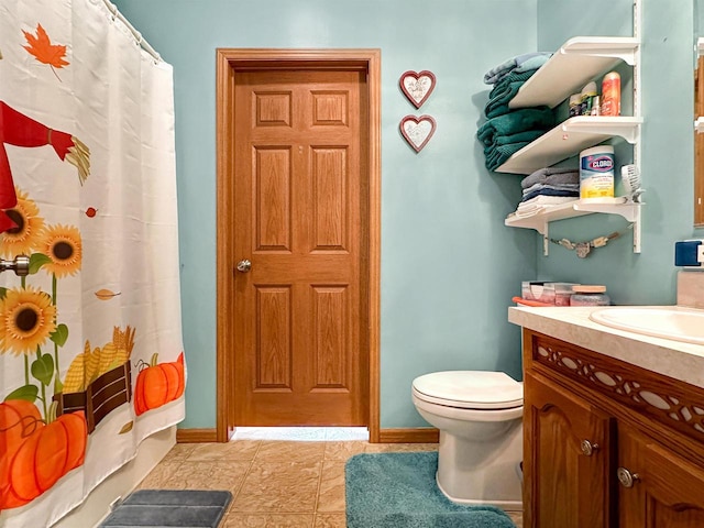 bathroom with vanity, walk in shower, toilet, and tile patterned floors