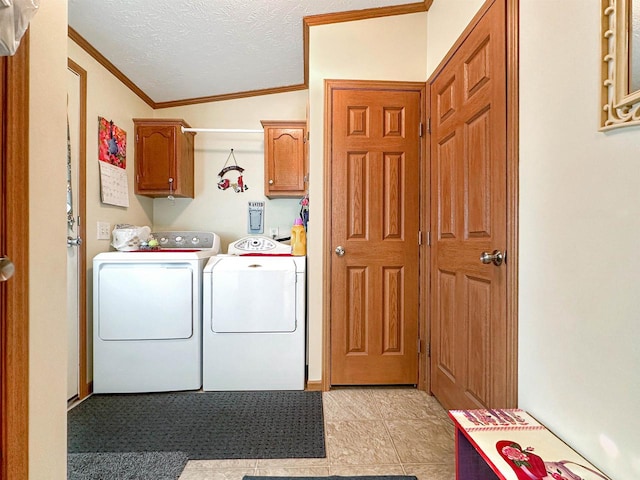 clothes washing area featuring a textured ceiling, ornamental molding, cabinets, and washing machine and clothes dryer