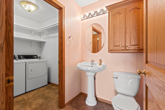 bathroom featuring washer and clothes dryer and toilet