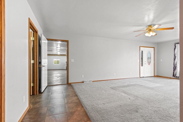 unfurnished room featuring dark tile patterned flooring and ceiling fan