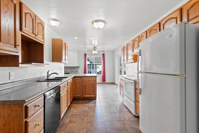 kitchen featuring dark tile patterned flooring, kitchen peninsula, sink, white appliances, and ceiling fan