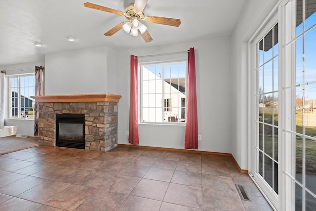 unfurnished living room featuring ceiling fan, tile patterned floors, and a fireplace