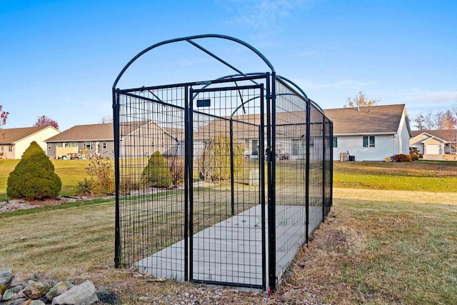 view of gate with a lawn