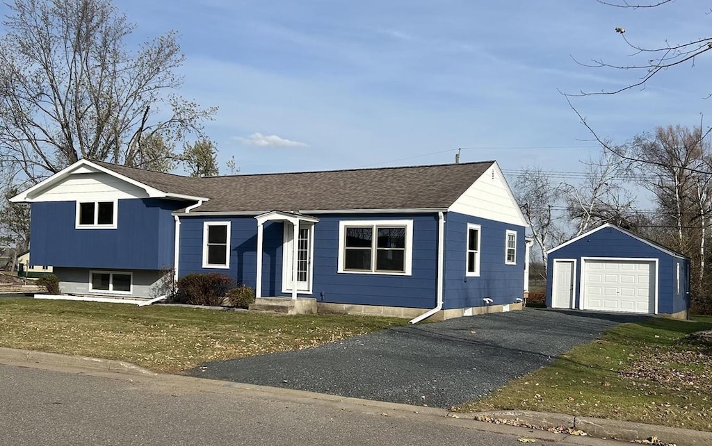 view of front of property featuring a garage, an outbuilding, and a front yard