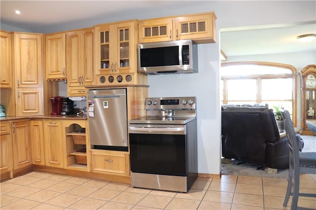 kitchen featuring stainless steel appliances, light tile patterned floors, and light brown cabinets