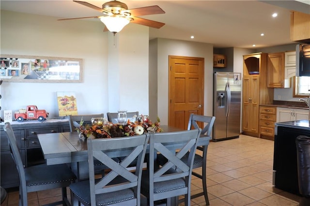 tiled dining space featuring sink and ceiling fan