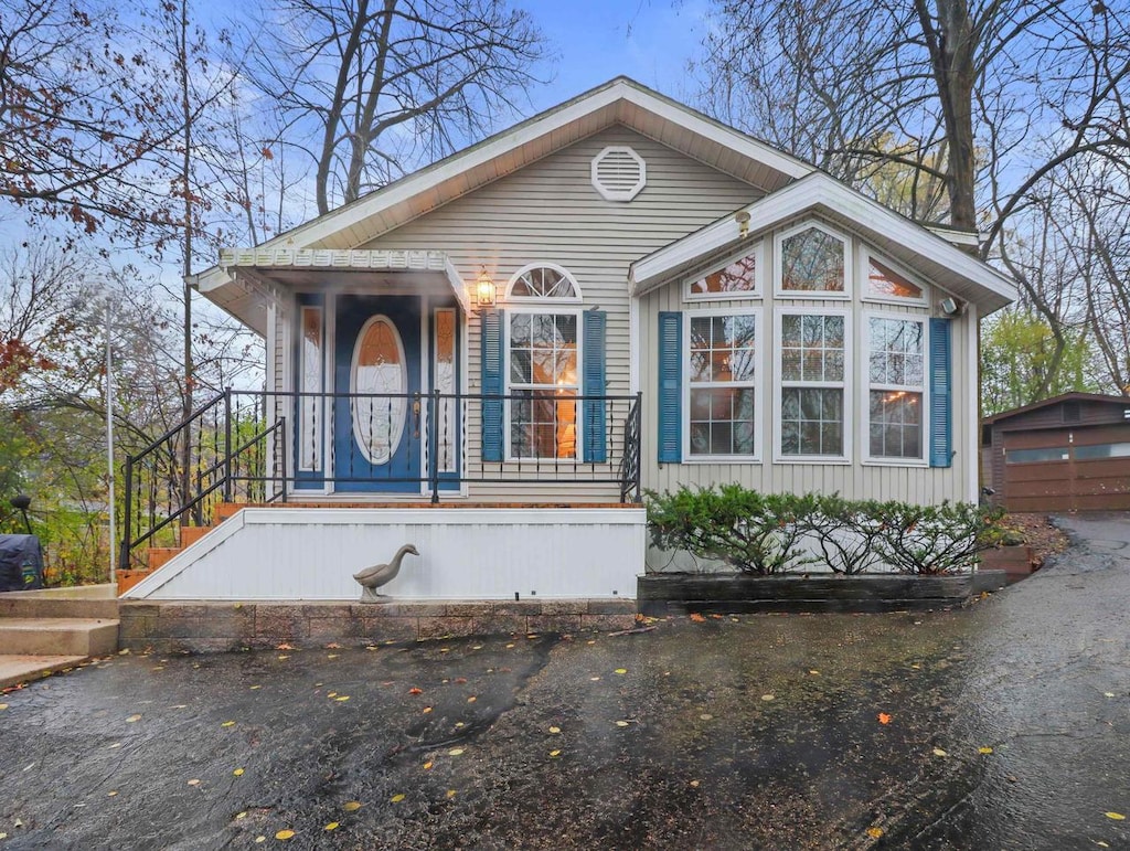 view of front of property featuring a porch and an outdoor structure