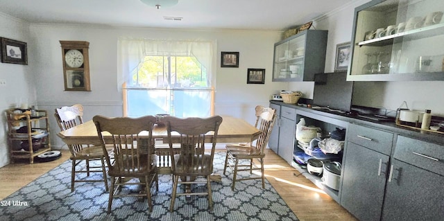 dining space with crown molding and hardwood / wood-style flooring