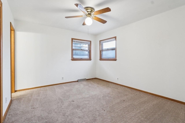 spare room featuring light carpet and ceiling fan