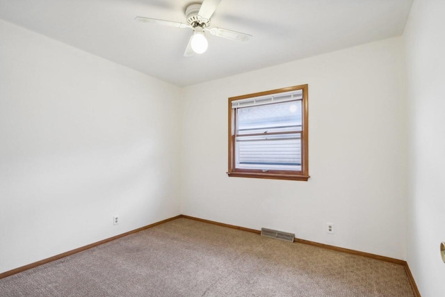 carpeted spare room featuring ceiling fan