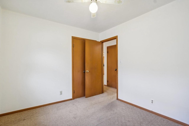 spare room featuring light carpet and ceiling fan