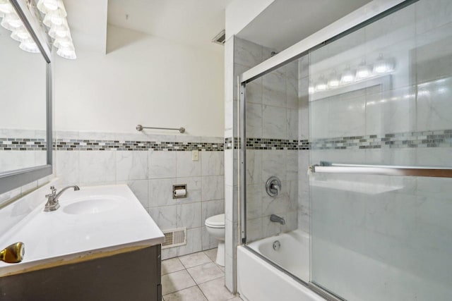 full bathroom with vanity, toilet, tile walls, and tile patterned flooring