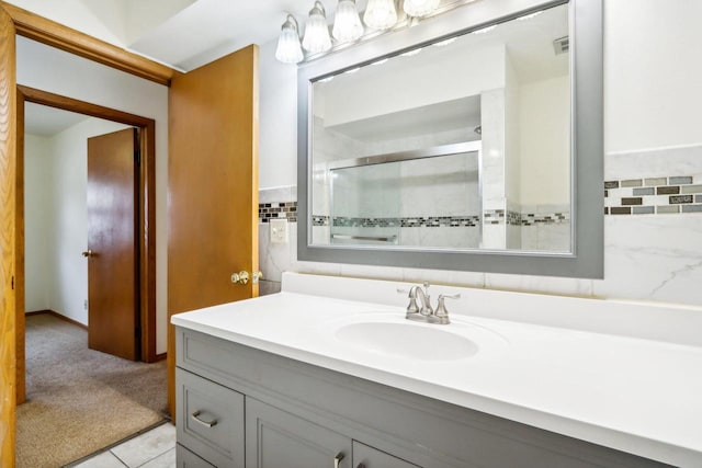 bathroom with tile walls, vanity, tile patterned floors, and an enclosed shower