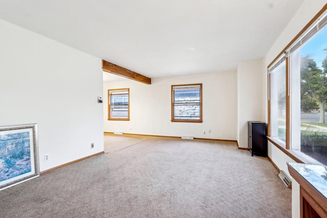 spare room with beamed ceiling and light colored carpet