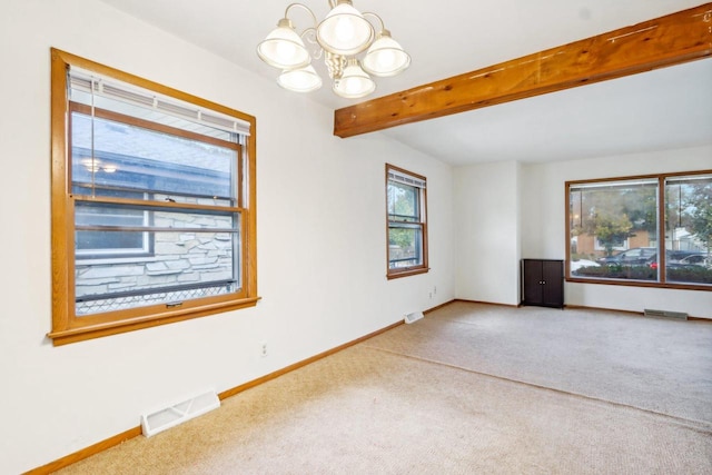 spare room featuring a notable chandelier, carpet floors, and beam ceiling