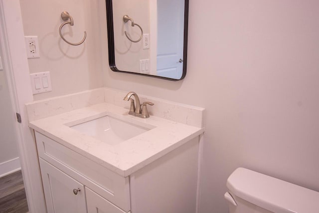 bathroom featuring vanity, wood-type flooring, and toilet