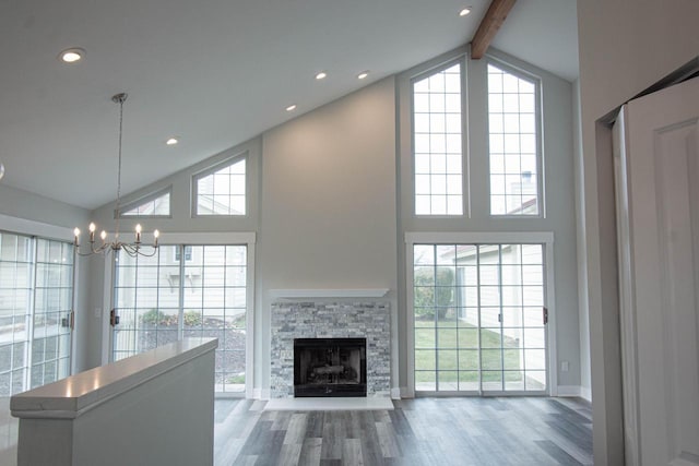 1642 Cottage Dr Unit 7-48, Lake Geneva, WI 53147 - unfurnished living room featuring an inviting chandelier, wood finished floors, a fireplace, beamed ceiling, and high vaulted ceiling