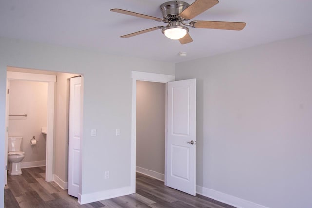 unfurnished bedroom featuring dark hardwood / wood-style floors, ensuite bathroom, and ceiling fan