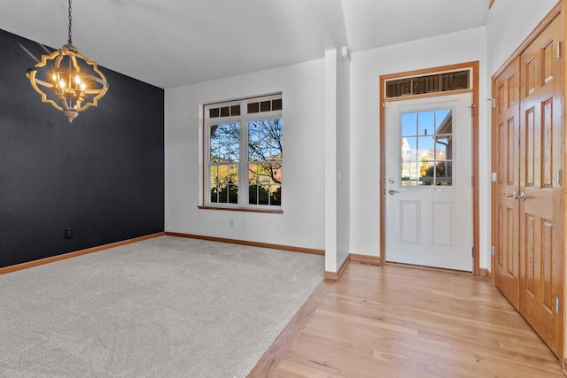 entryway featuring light hardwood / wood-style flooring and a chandelier