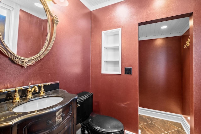 bathroom with vanity, toilet, crown molding, and tile patterned floors