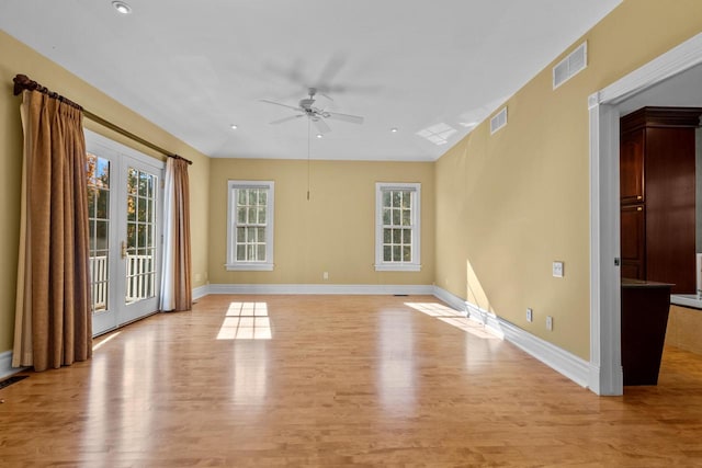 empty room with french doors, light hardwood / wood-style floors, and ceiling fan