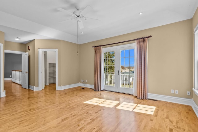 empty room with french doors, light wood-type flooring, and ceiling fan