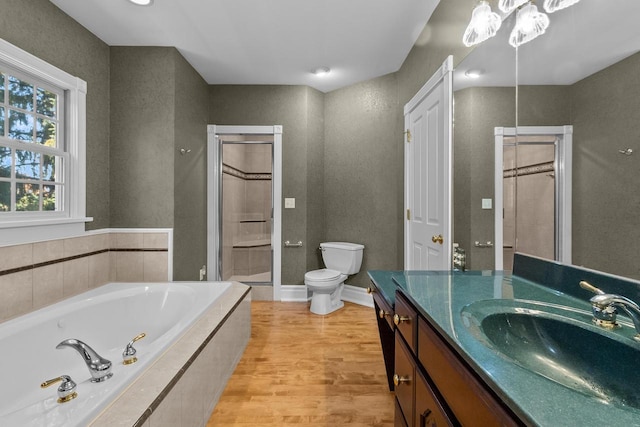 full bathroom with vanity, hardwood / wood-style floors, plus walk in shower, and toilet