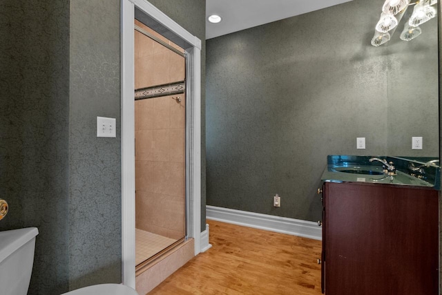 bathroom with vanity, wood-type flooring, toilet, and an enclosed shower