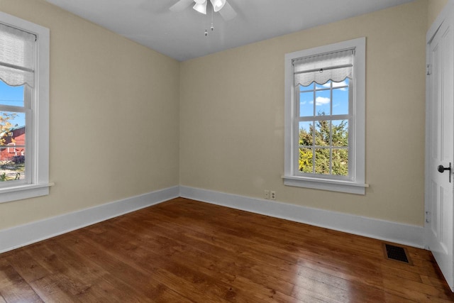 spare room with hardwood / wood-style flooring, a healthy amount of sunlight, and ceiling fan