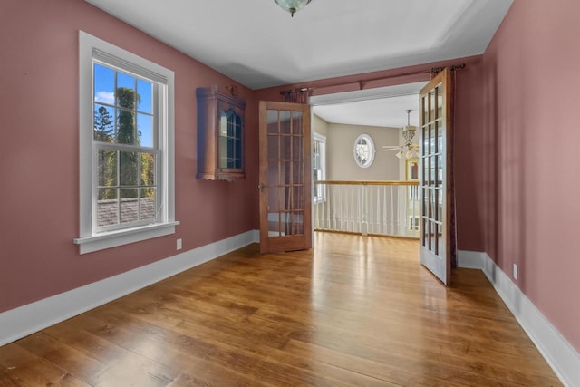 empty room featuring french doors, ceiling fan, and hardwood / wood-style floors