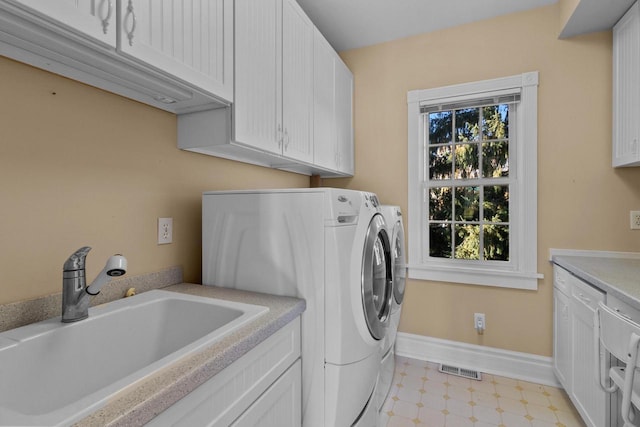 laundry room featuring cabinets, sink, and washing machine and clothes dryer