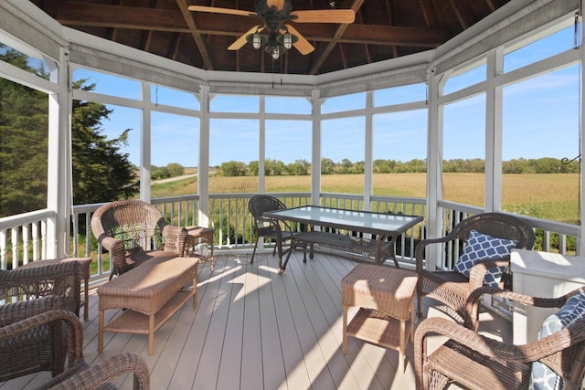 sunroom with vaulted ceiling with beams and a rural view