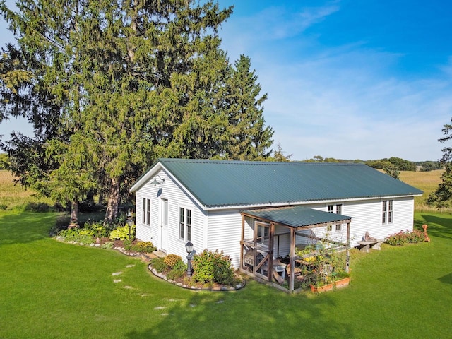 rear view of property featuring a lawn