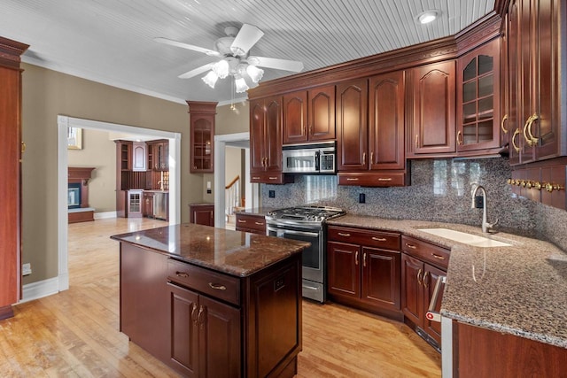 kitchen featuring light hardwood / wood-style floors, tasteful backsplash, appliances with stainless steel finishes, and sink