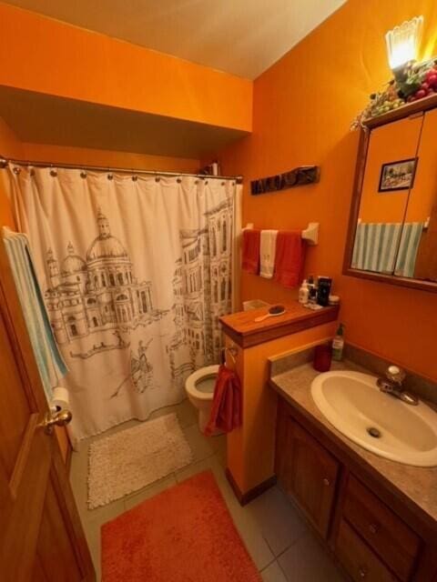 bathroom featuring vanity, a shower with curtain, toilet, and tile patterned flooring