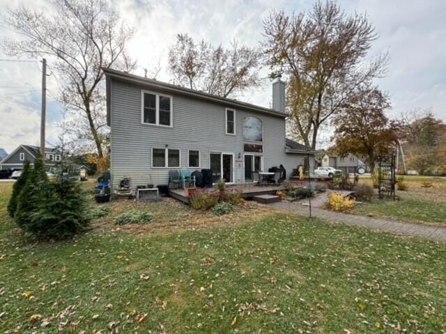 rear view of house with a yard and a wooden deck